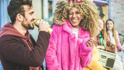 Trendy people from diverse culture making party outdoor drinking beer, smoking and listening music - Young friends having fun on weekend evening day - City life concept - Focus on afro girl face