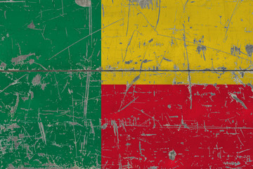 Grunge Benin flag on old scratched wooden surface. National vintage background.