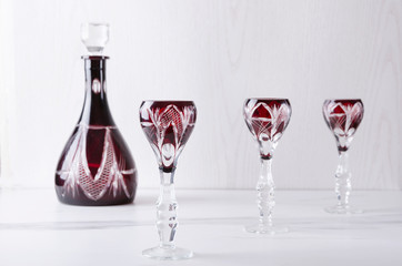 Old-fashioned glasses and decanter on the white table against white wall.Set of glassware for aclcoholic drinks