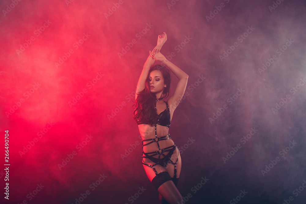 Poster Nice attractive fascinating charming sportive perfect figure wavy-haired lady wearing swordbelt teasing posing closed eyes enjoying lifestyle night club clubber isolated on red light black background