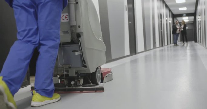 Close up of female legs with floor-washing machine