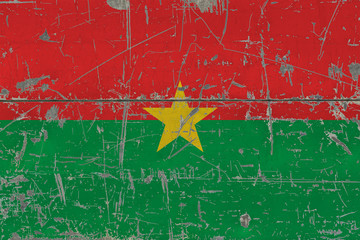 Grunge Burkina Faso flag on old scratched wooden surface. National vintage background.