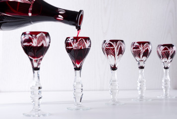 Pouring red bitter alcoholic drink into vintage glasses.Concept of buffet dinner