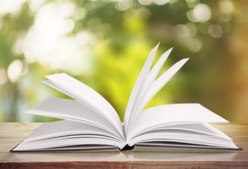Open book on old wooden table.