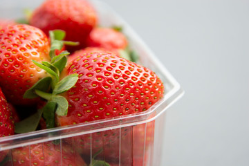 Strawberries in plastic box pack background. Zero waste concept, no plastic