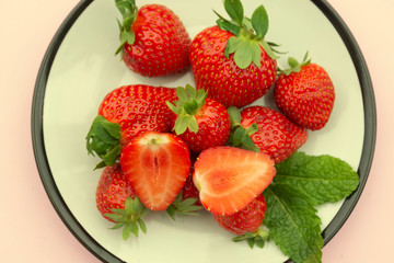Styled flat lay strawberries in a plate. Summer fresh berries over pink background.