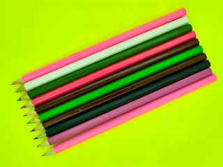 Colored pencil crayons on yellow background