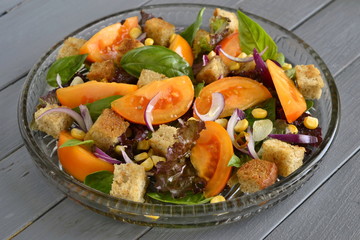 Salad with yellow tomatoes, sweet corn, basil and croutons, panzanella