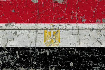 Grunge Egypt flag on old scratched wooden surface. National vintage background.