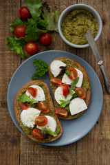 Pesto toast with mozzarella cheese, cherry tomatoes, bruschetta toast on wooden background. Healthy breakfast ,snack.