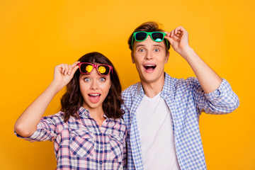 Close up photo of pair in raised up summer specs he him his she her lady boy did not expect free flight on travel open mouth wearing casual plaid shirts outfit isolated on yellow background