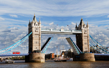 Fototapeta na wymiar Tower Bridge, lifted over dramatic cloudy sky.