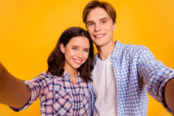 Close up photo of pair in love he him his she her lady boy telling relatives on web camera skype news about engagement   wearing casual plaid shirt outfit isolated on yellow background
