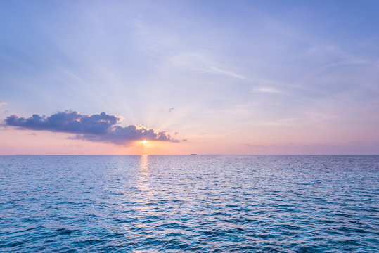 Sunrise in the Maldives. Delicate watercolor colors of the sunrise.