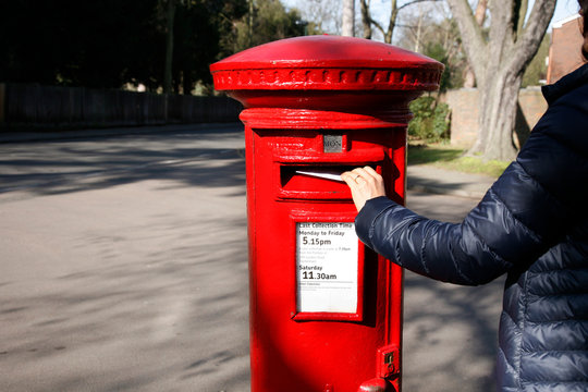 Traditional British red post box in an residential area.