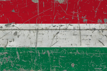 Grunge Hungary flag on old scratched wooden surface. National vintage background.