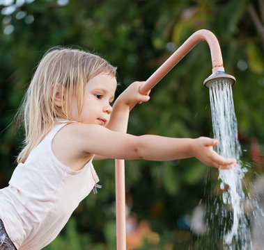 Child girl washing hands outdoors