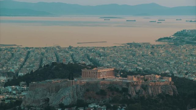 Time lapse. Acropolis with Parthenon. View through a frame with green plants, trees, ancient marbles and cityscape, Athens, Greece.