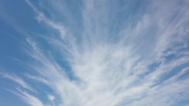 Scenic cirrus lenticular clouds in timelapse with awesome white filaments of clouds and light effects surrounded by a blue summer sky