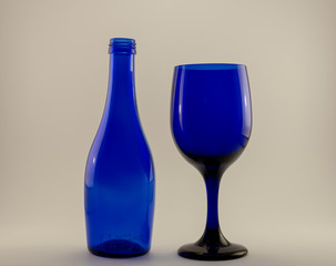 blue wine glass and blue bottle on a white back ground