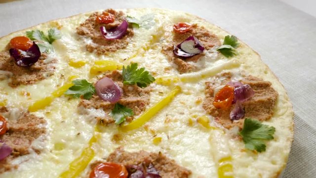Italian food. Delicious traditional pizza topped with cream sauce, fresh parsley, dried tomatoes, red onion, parmesan cheese, bell pepper, minced beef meat, cumin seeds. Slow motion. HD