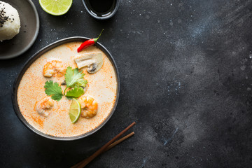 Tom yam kung spicy thai soup with shrimp, seafood, coconut milk, chili pepper and rice. View from above. Space for text.