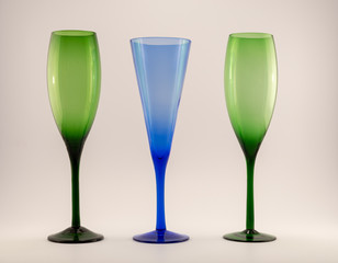 two green glasses and a blue champagne glass on a white black ground