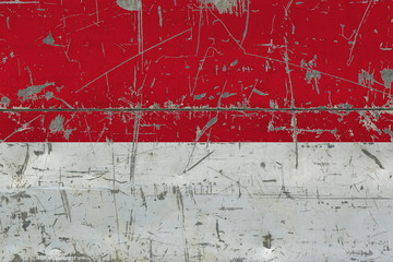 Grunge Monaco flag on old scratched wooden surface. National vintage background.