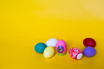 composition of colored Easter eggs on a yellow background