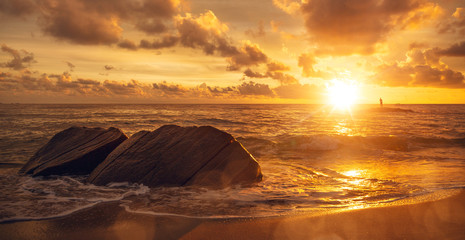 Eindrucksvoller Sonnenaufgang am Meer mit Person am Horizont