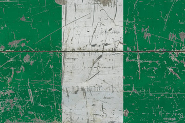 Obraz premium Grunge Nigeria flag on old scratched wooden surface. National vintage background.