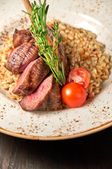 Knuckle meat dish with a side dish on a blue plate. Dark wooden background.