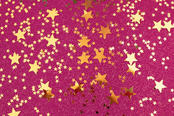 Golden stars confetti on pink background.