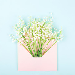 Bouquet of lily of valley in pink envelope.