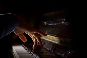 one male hand on the piano. The palm lies on the keys and plays the keyboard instrument in the...