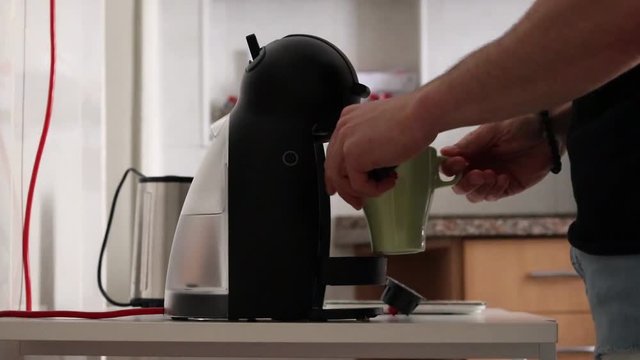 Man making coffee with a coffee machine, side view.