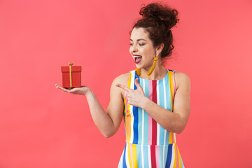 Happy pretty redhead woman in dress holding gift box