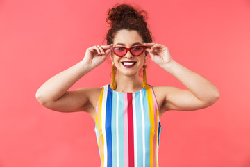 Pleased pretty redhead woman in dress holding sunglasses