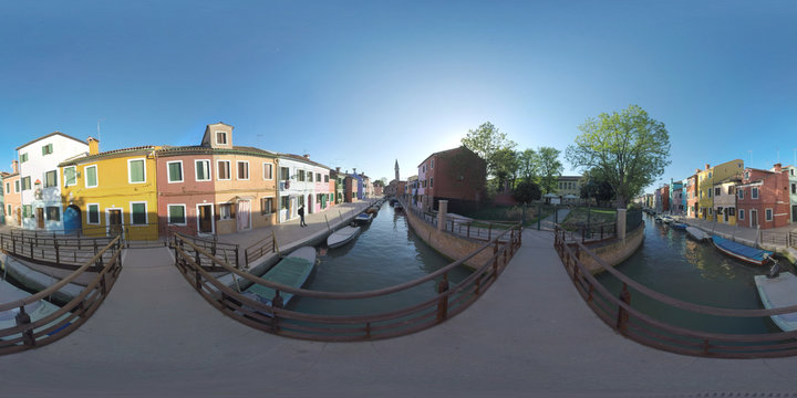 360 photo - Scenic townscape of Burano island in Italy. Rows of painted homes along the canal with boats. View with Campanile of San Martino church. Shot with bell ring