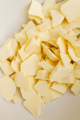 Pieces of butter are in a bowl for mixing in the preparation of cookies