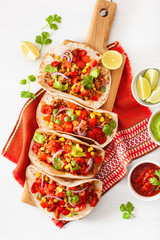 mexican beef and pork tacos with salsa, guacamole and vegetables