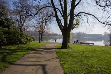 People riding bicycle, jogging and hiking in a green city park in the Netherlands