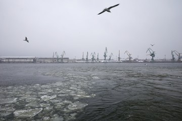 ferry trip in Lithuania to the city of Klaipeda in the winter season overlooking the bay with access to the Baltic Sea, and with cranes in the port