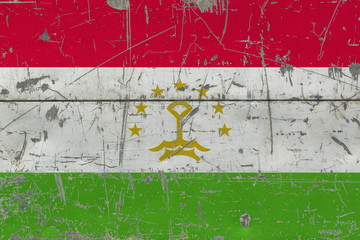 Grunge Tajikistan flag on old scratched wooden surface. National vintage background.