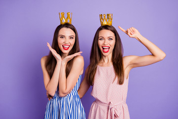 Close up portrait two people beautiful she her models chic ladies hands arms palms air power status gold crowns head yelling wear summer colorful dresses isolated purple violet bright background