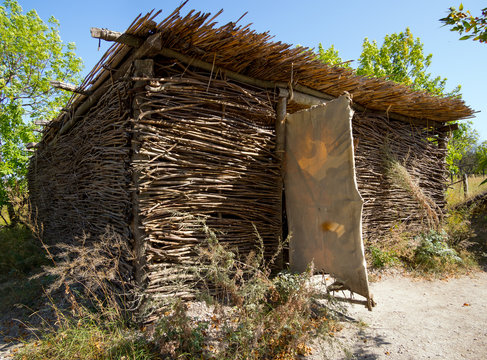 A hut with walls of interlaced twigs, covered with reeds