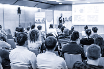 Speaker giving talk at business event. Audience at the conference hall. Business and...