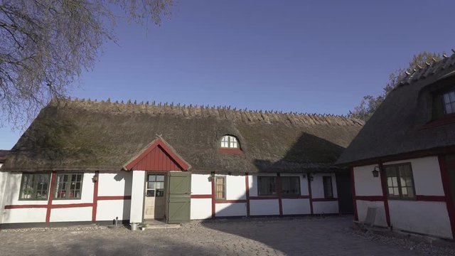 Timbered red and white old farm buildings with straw roof from the 1700 hundreds