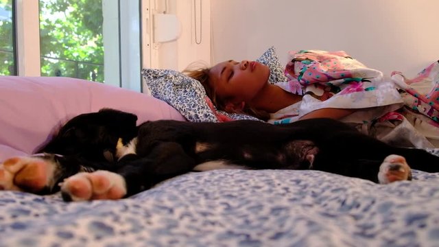 Asian girl wakes up and kisses a puppy that was sleeping with her!