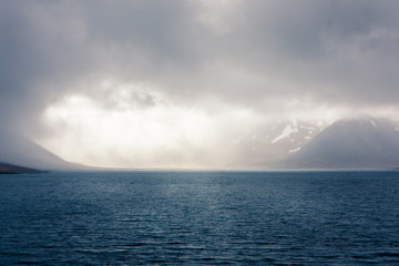 The mountains rise above the water column, with beautiful sunlight and haze